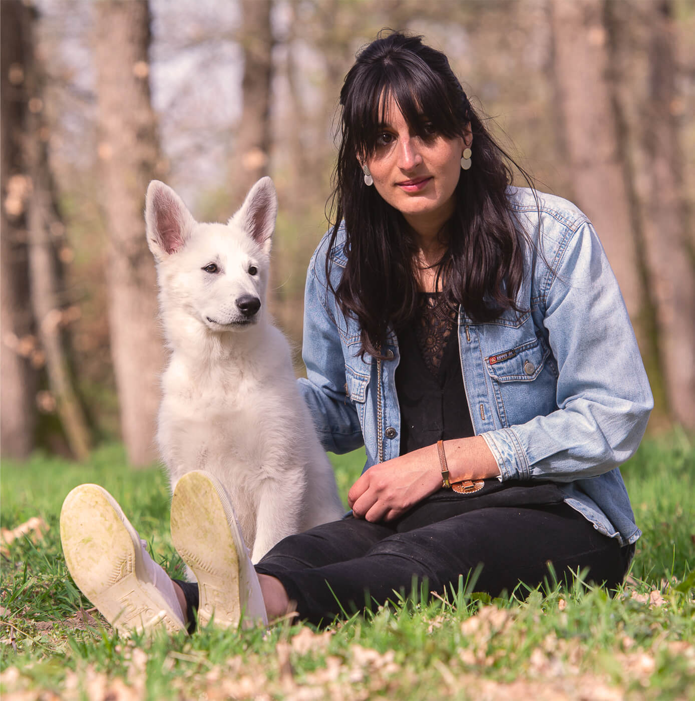 La propriétaire et son chien assis dans l’herbe