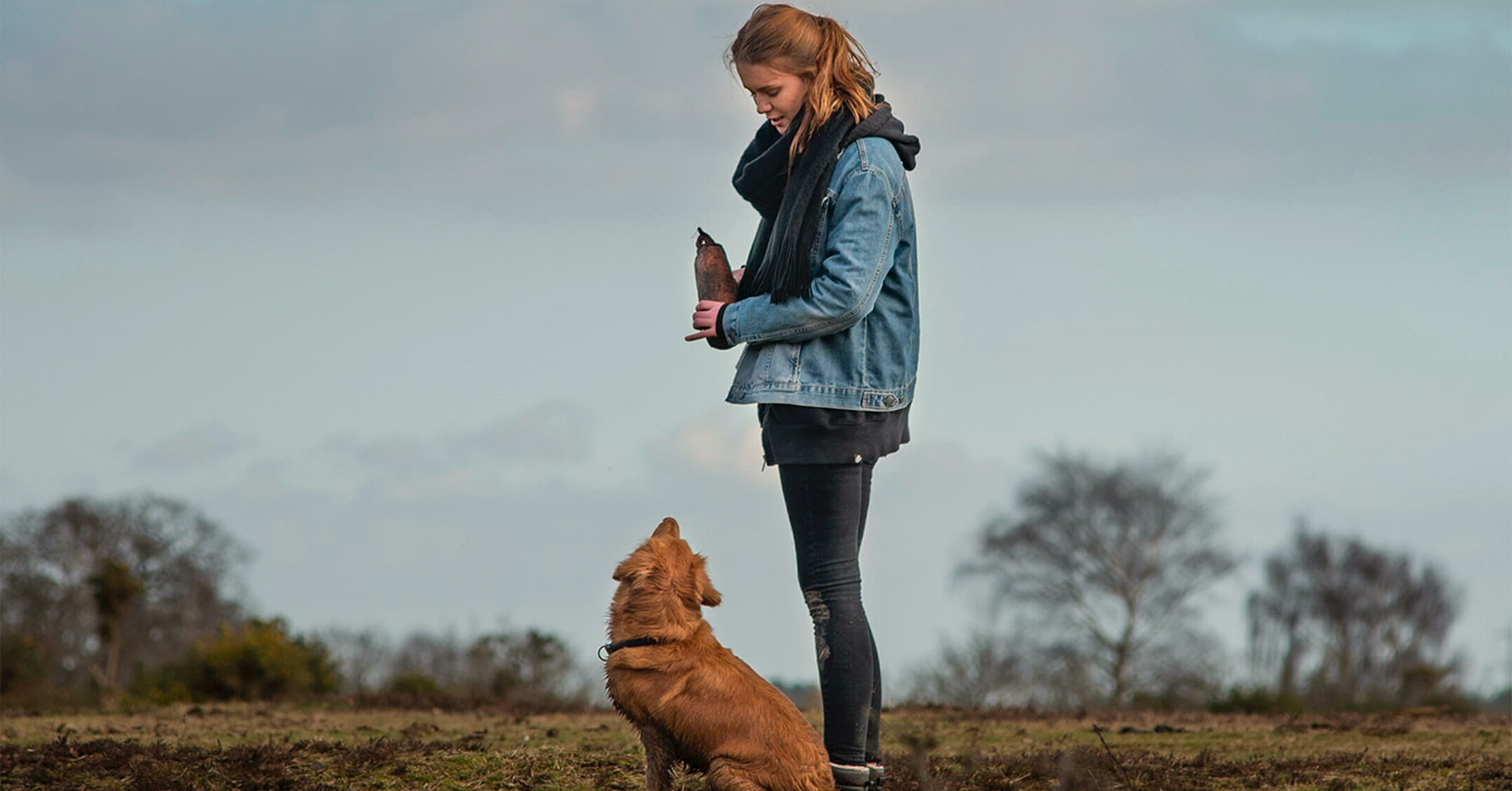 Propriétaire et son chien assis qui se regardent en extérieur