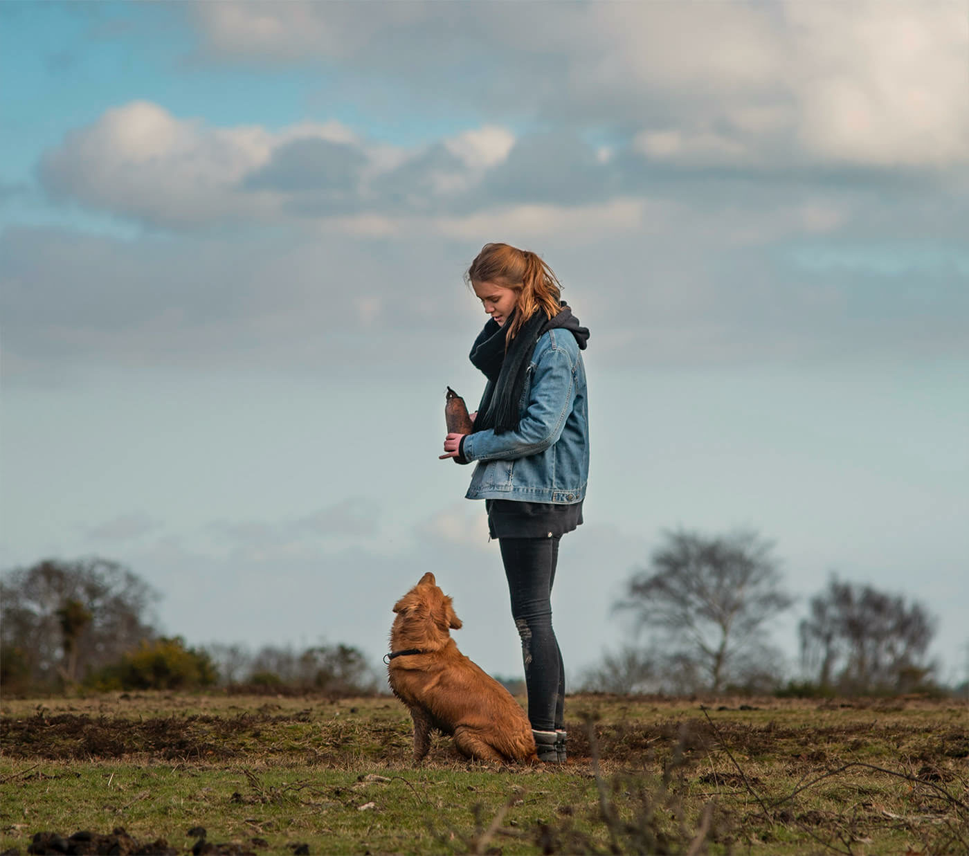 Propriétaire et son chien assis qui se regardent en extérieur