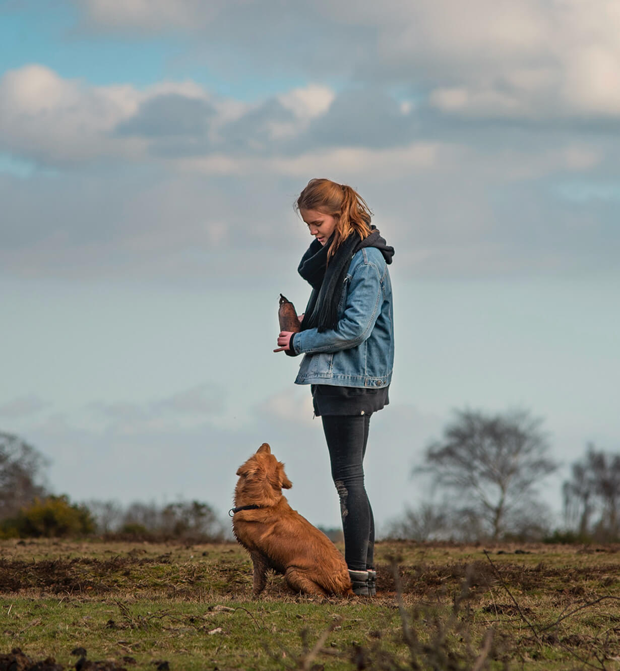 Propriétaire et son chien assis qui se regardent en extérieur