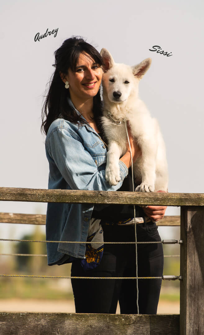 La propriétaire et son chien derrière une barrière